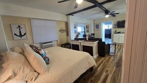 Ein Schlafzimmer mit einem Bett, einem Schreibtisch und einer Küchenzeile.