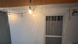 A room with a white wall, a barred window, and string lights. - Apartment Amanecer Isleño 7 5 min from the beach (Isla Mujeres)