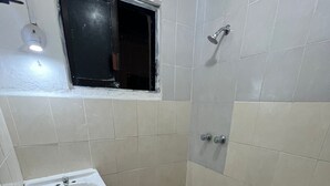 A small, tiled bathroom with a white sink, a toilet, and a shower area. - Apartment Amanecer Isleño 7 5 min from the beach (Isla Mujeres)