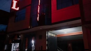 Un hotel con un llamativo letrero de neón rojo que dice 'HOTEL'.