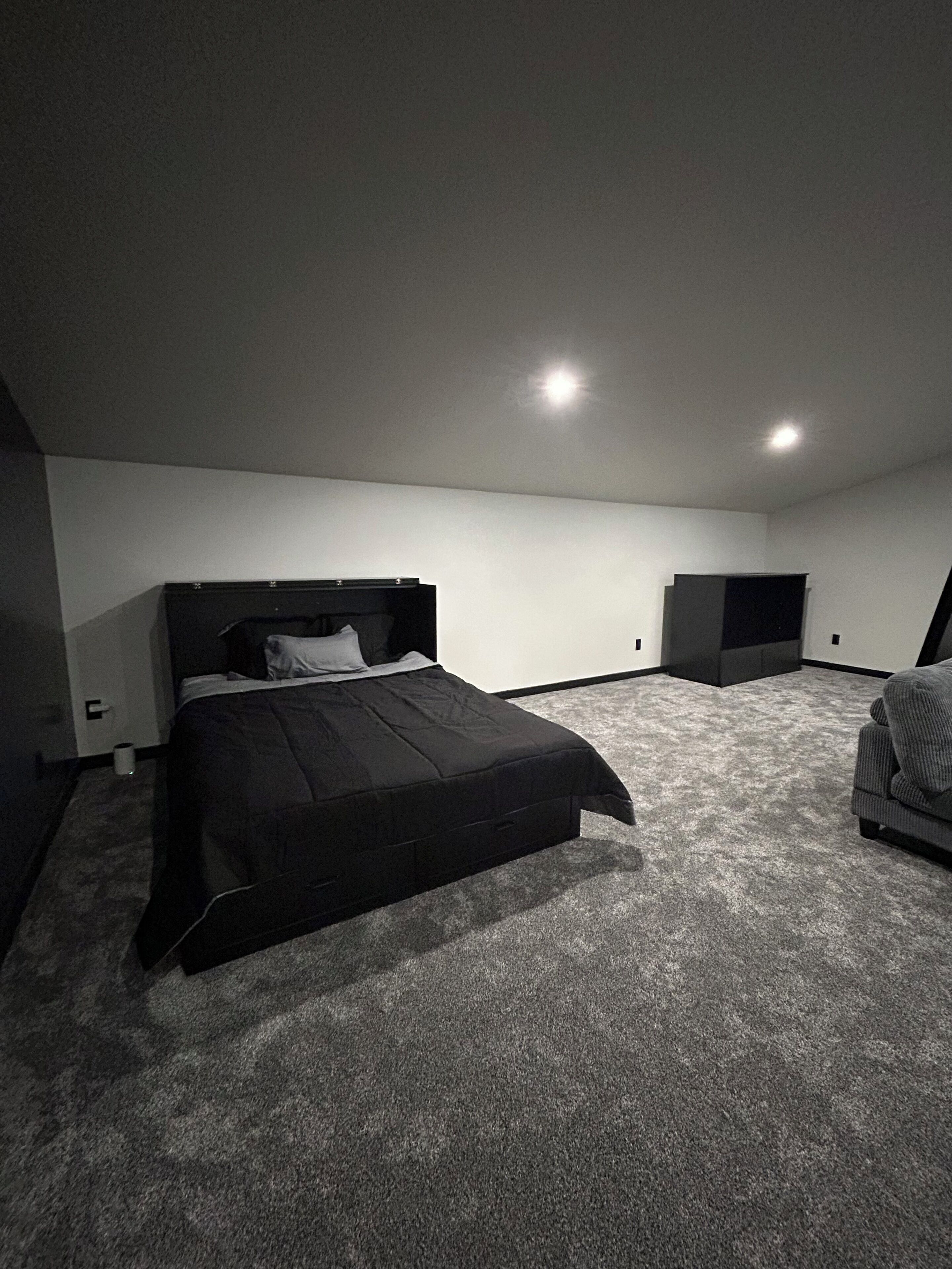 Un dormitorio con cama, una silla y un escritorio pequeño.