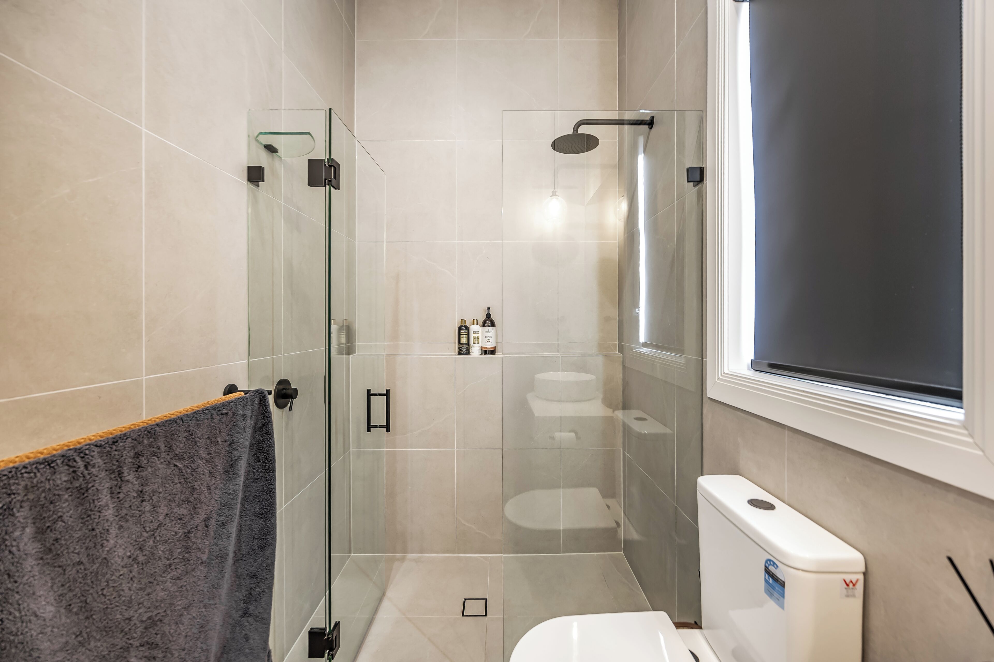 Een moderne badkamer met een douchecabine van glas, een toilet en een bidet.