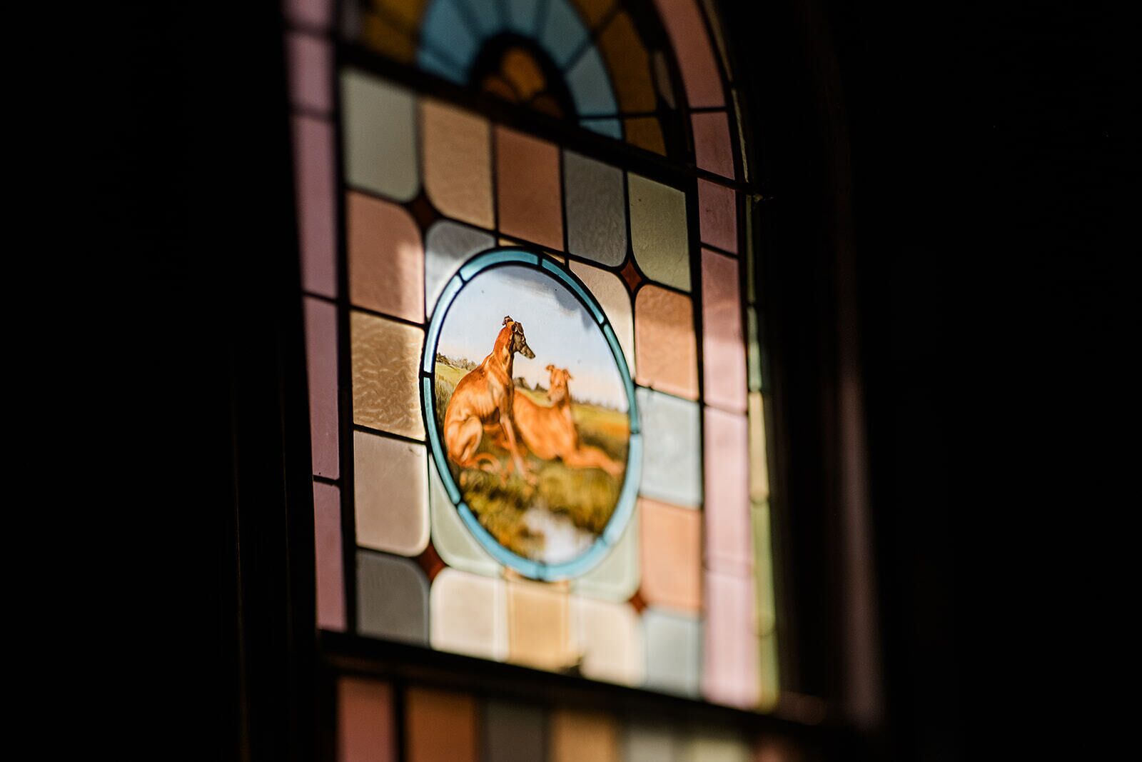Una ventana de vitral con una representación de caballos.
