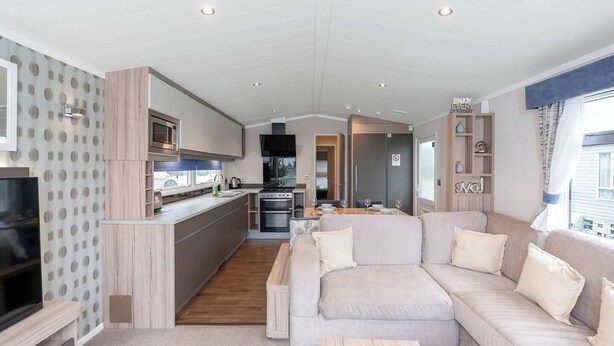 Un espace de vie moderne et compact, comprenant un coin cuisine, un canapé et un espace repas.