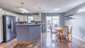 Una cocina moderna con una isla central, mesa de comedor de madera y sillas.