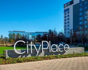 Ein Hotel Eingang mit einem Schild mit der Aufschrift 'CityPlace' und einem modernen Gebäude im Hintergrund.