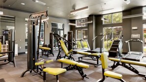 Uma academia moderna com diversos equipamentos de ginástica, amplas janelas e piso de azulejos impecável.