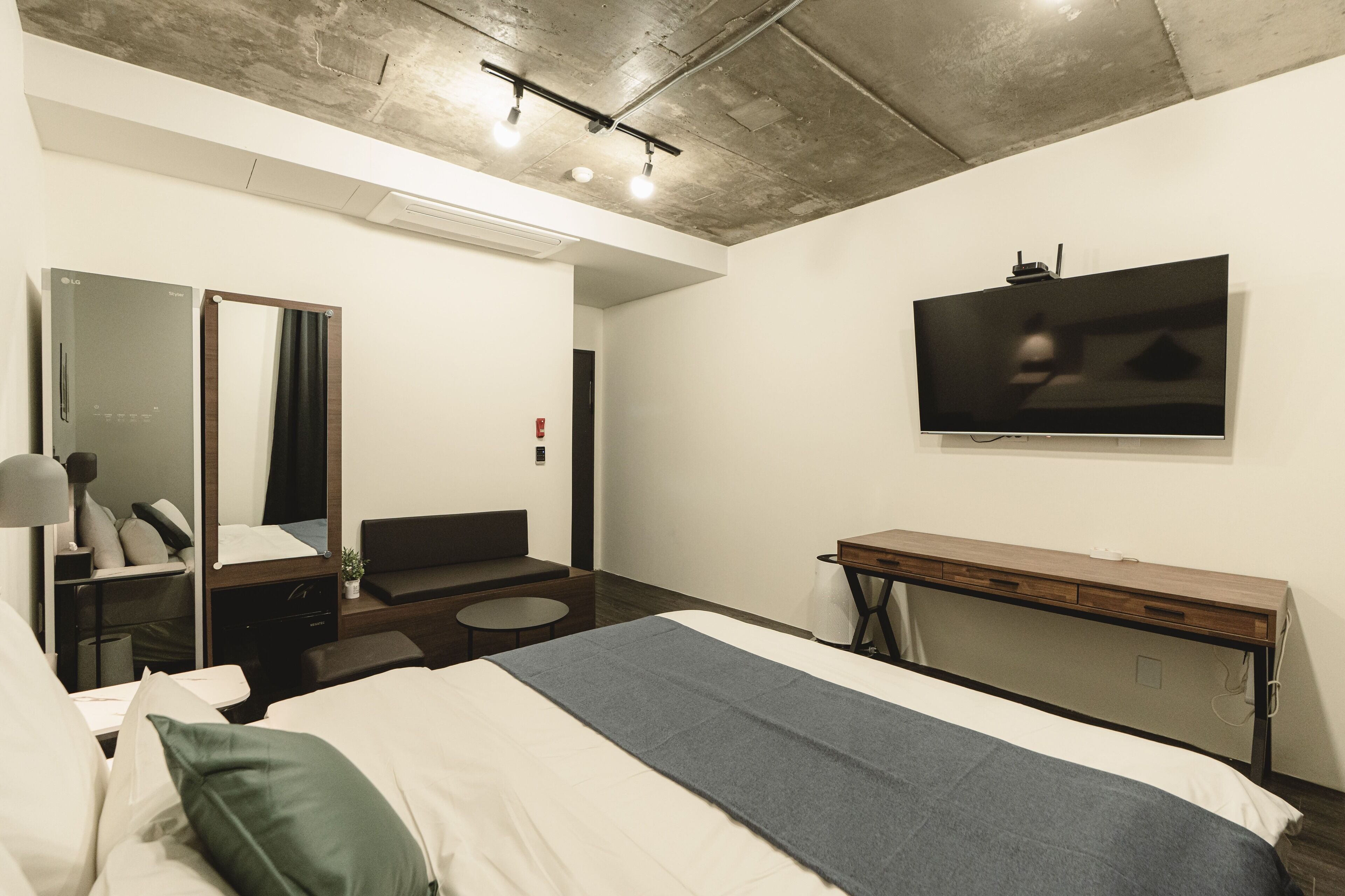 Een moderne hotelkamer met een groot bed, een bureau, een televisie en een spiegel.