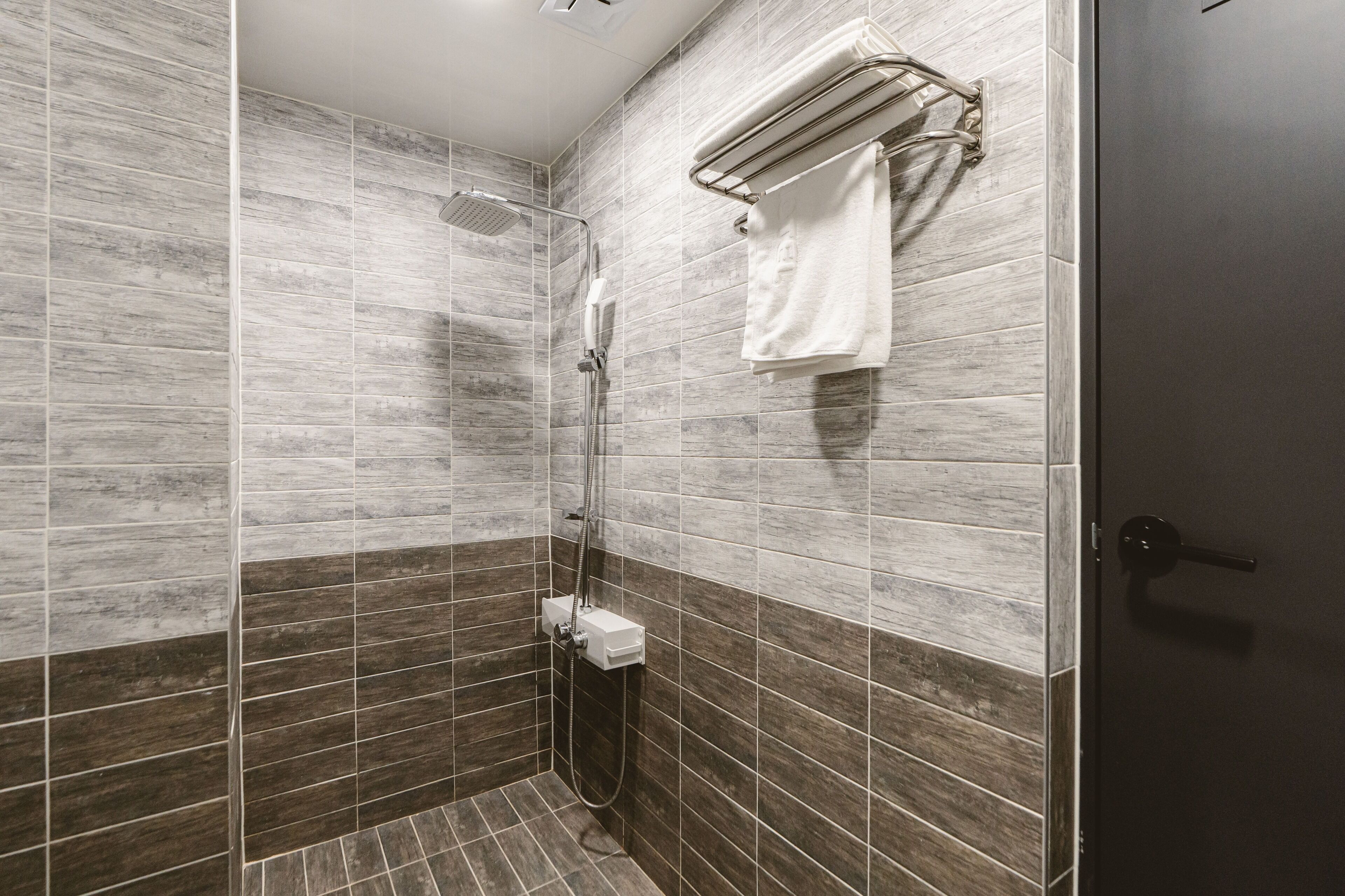 Un baño moderno con ducha, toallero y retrete.