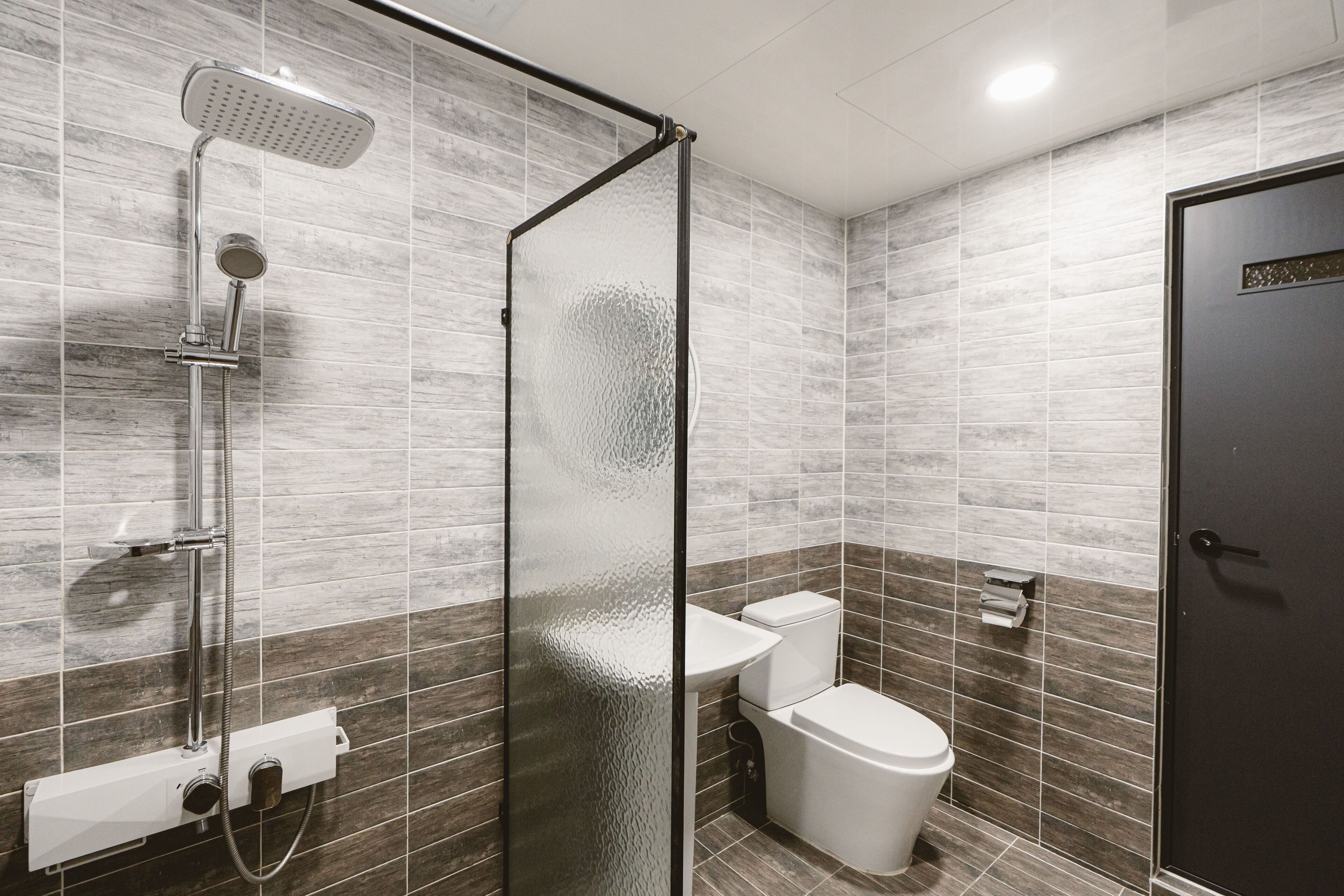 Un baño moderno con ducha de vidrio, inodoro y lavamanos.