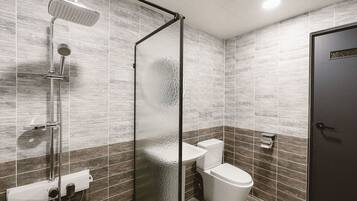 Un baño moderno con ducha de vidrio, inodoro y lavamanos.
