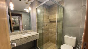 A modern bathroom with a granite countertop, a glass-enclosed shower, and a toilet. - 2nd tallest building in Curitiba built (Curitiba)