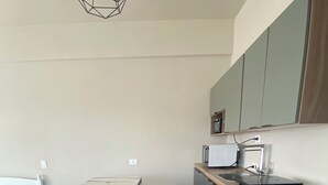 A compact kitchen with a microwave, sink, and wooden cabinets. - 2nd tallest building in Curitiba built (Curitiba)