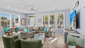 A spacious living room with a sectional sofa, a coffee table, and a TV mounted on the wall. - Ocean View Surfside House w/ Pool & Walk to Bars (Surfside Beach)