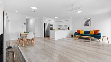 A modern apartment with a dining area, kitchen, and living room.