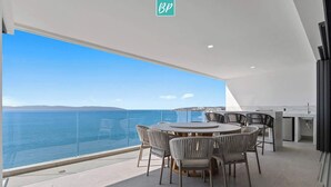 A modern dining area with a panoramic sea view, a round table, and contemporary chairs. - 4BR Hidden Gem: Luxe Oceanfront Living in Bucerias (Bucerías)