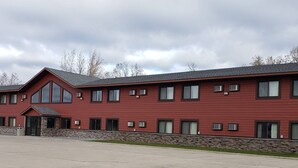 A red building with multiple windows and a stone foundation.