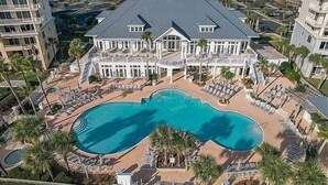 Ein großes Resort mit einem zentralen Schwimmbad, zahlreichen Gästezimmern und Meerblick.