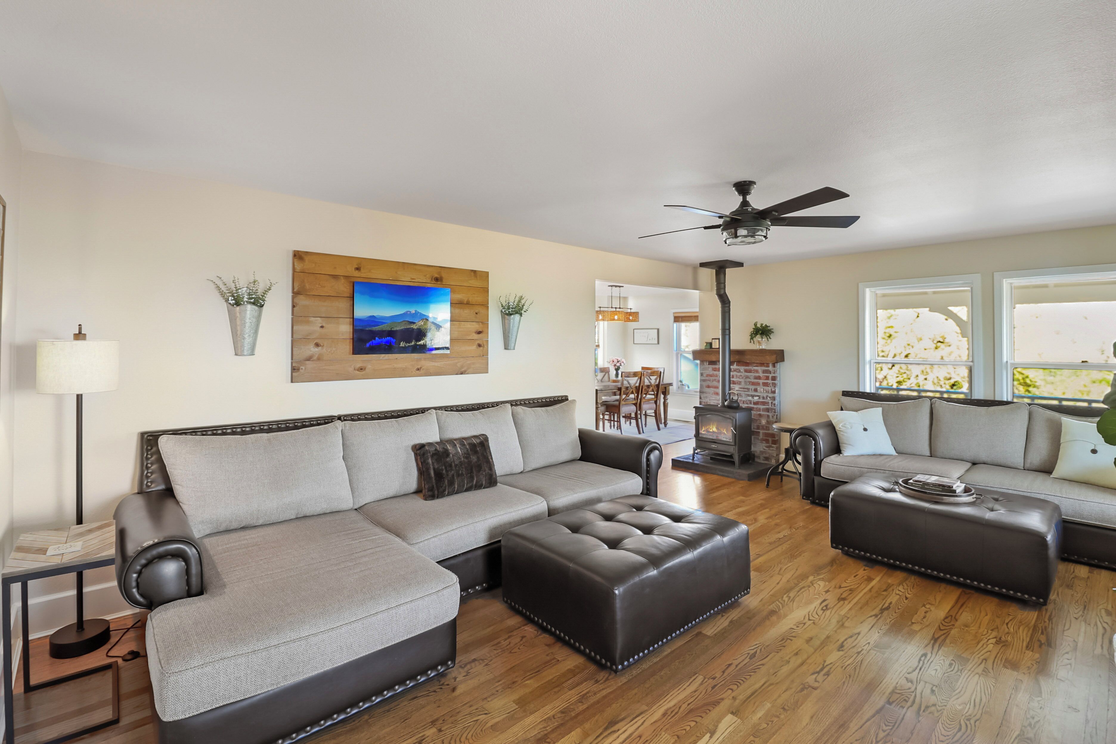 A spacious living room with a sectional sofa, ottoman, and a fireplace.