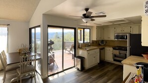A spacious kitchen with a dining area, large windows, and a view of the outdoors. - Naci Vista Retreat - Incredible Lake Views (Bradley)