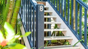 A staircase with a blue railing and the number 8 on the side, surrounded by greenery.