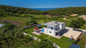 Et moderne hus med pool, terrasse og havudsigt.
