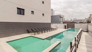 A rooftop swimming pool with lounge chairs and a tiled wall. - Sambadrome | Allianz Parque | Expo Center Norte | Bom Retiro. (São Paulo)