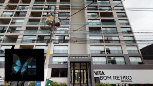A multi-story residential building with balconies, a sign for 'VITA BOM RETIRO', and a utility pole with wires. - Sambadrome | Allianz Parque | Expo Center Norte | Bom Retiro. (São Paulo)