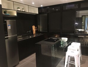 A modern kitchen with a central island, stainless steel appliances, and a glass backsplash. - Sambadrome | Allianz Parque | Expo Center Norte | Bom Retiro. (São Paulo)