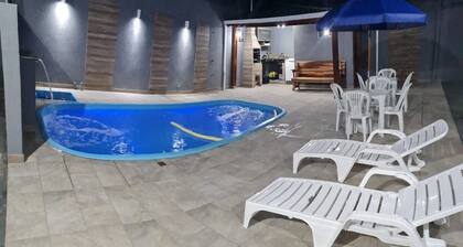 Two-story house with 4 suites in Matinhos-PR, near the city center, with a swimming pool.