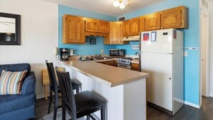 A compact kitchen with wooden cabinets, a white refrigerator, a microwave, and a coffee maker. - Cozy 1-bedroom condo in tranquil Osage Beach surrounded by all the Hot Spots!! (Osage Beach)