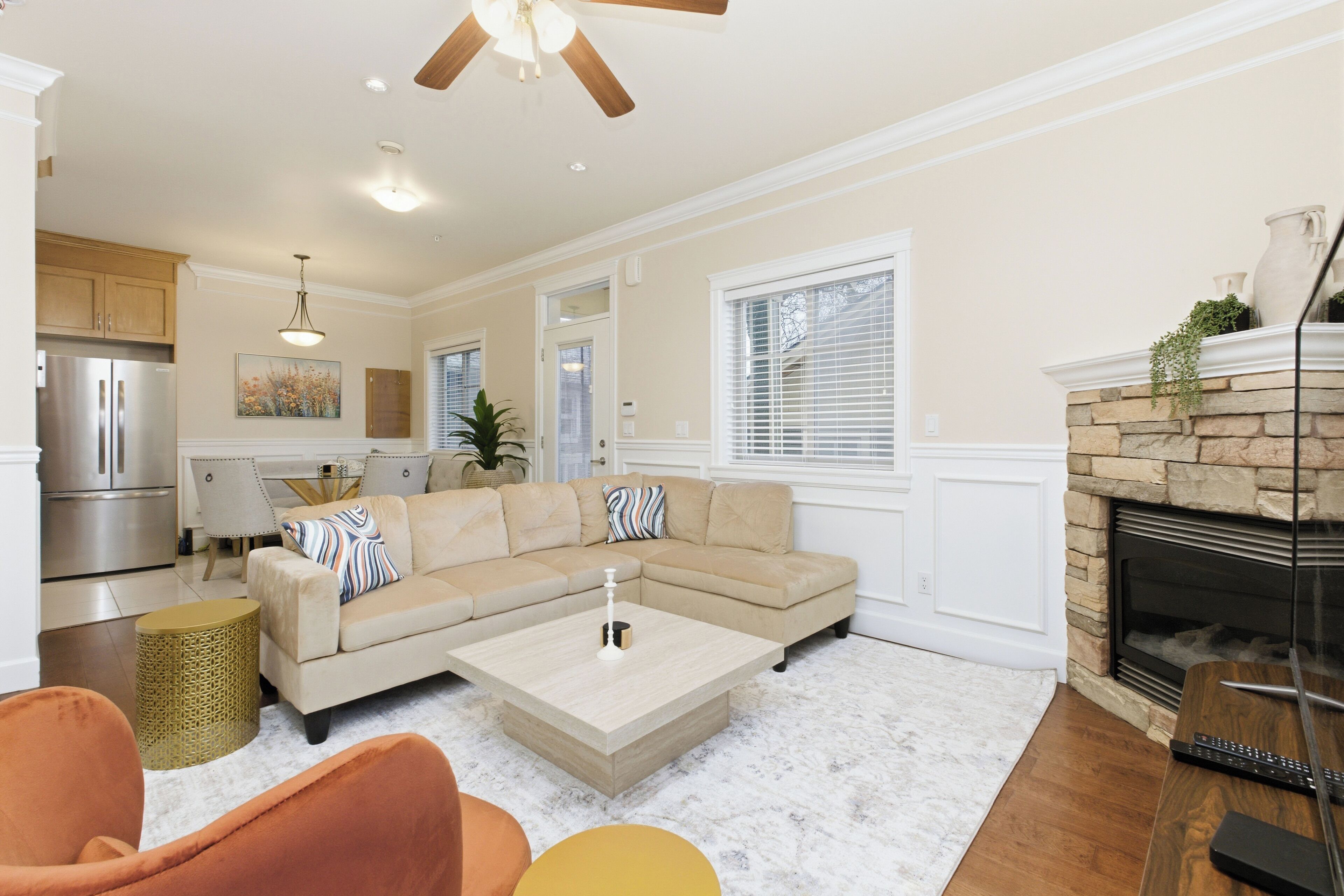 A modern living room with a sectional sofa, a coffee table, and a fireplace.