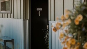 A guest entrance with a 'Registered Guest Only' sign, a bench, and a door.
