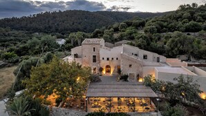 A stone building with multiple rooms and a patio area with outdoor seating. - The Lodge Mallorca (Sa Pobla)