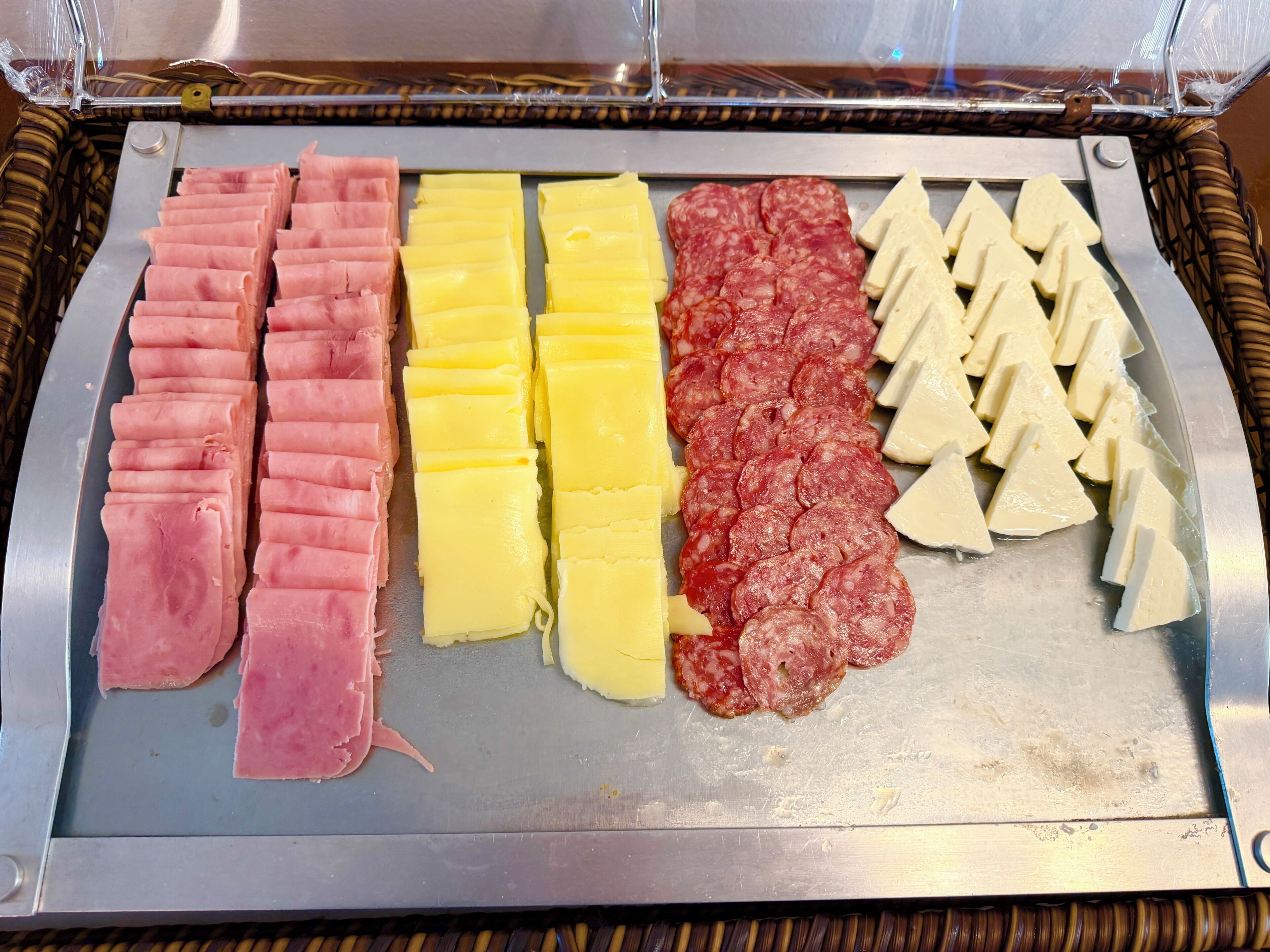 Una variedad de carnes y quesos en una bandeja.