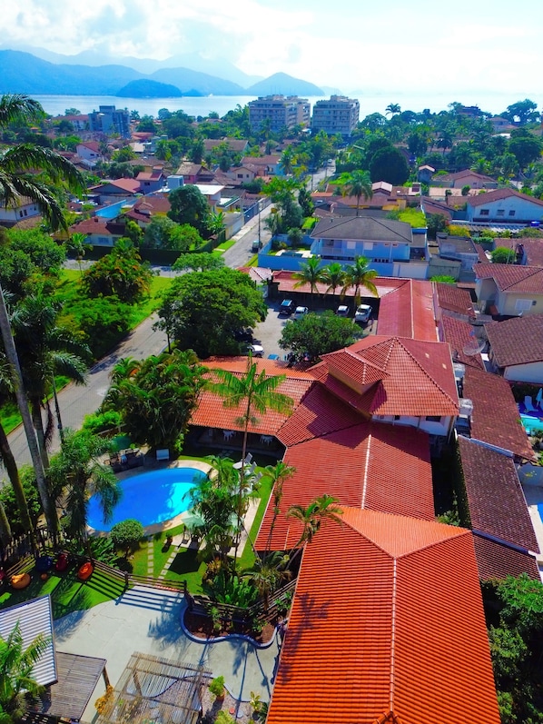 A residential area with a swimming pool, red-roofed buildings, and lush greenery.