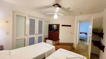 A hotel room with two beds, a TV, a ceiling fan, and a staircase leading to another room.