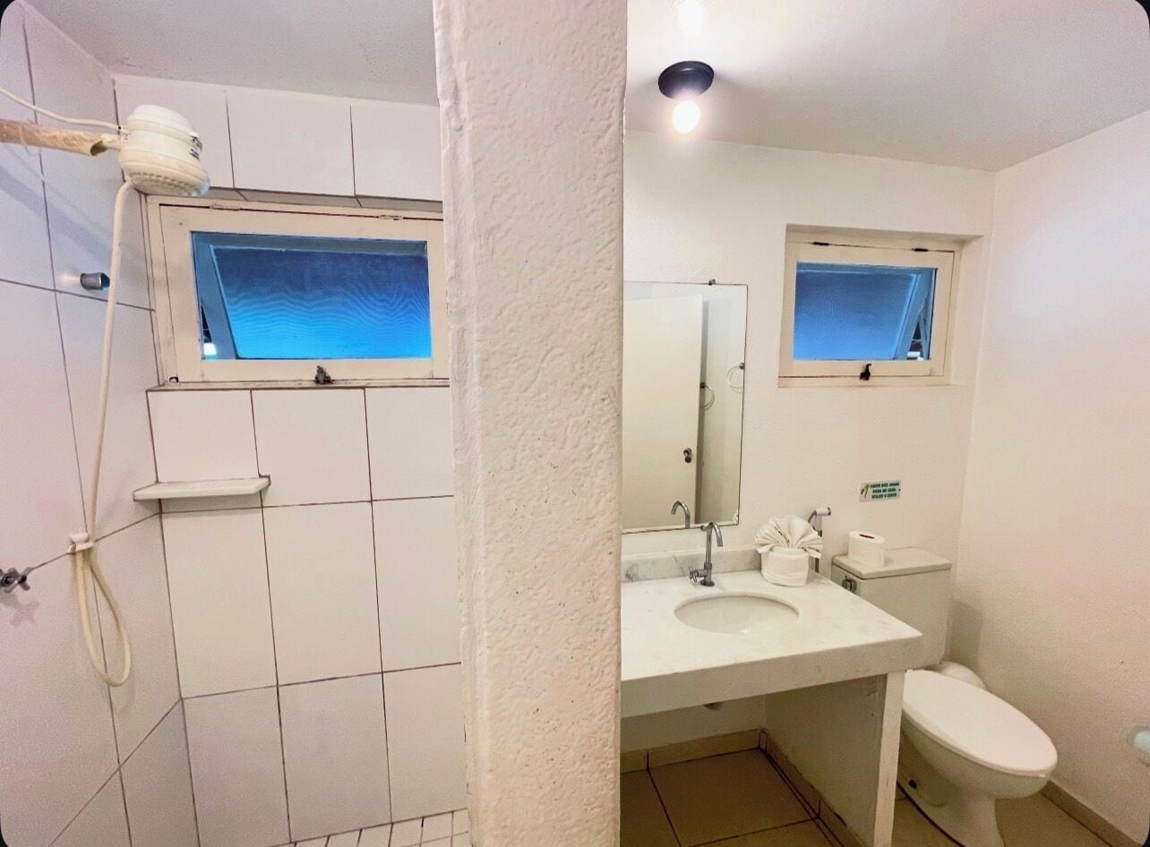 A bathroom with a shower, toilet, and sink.