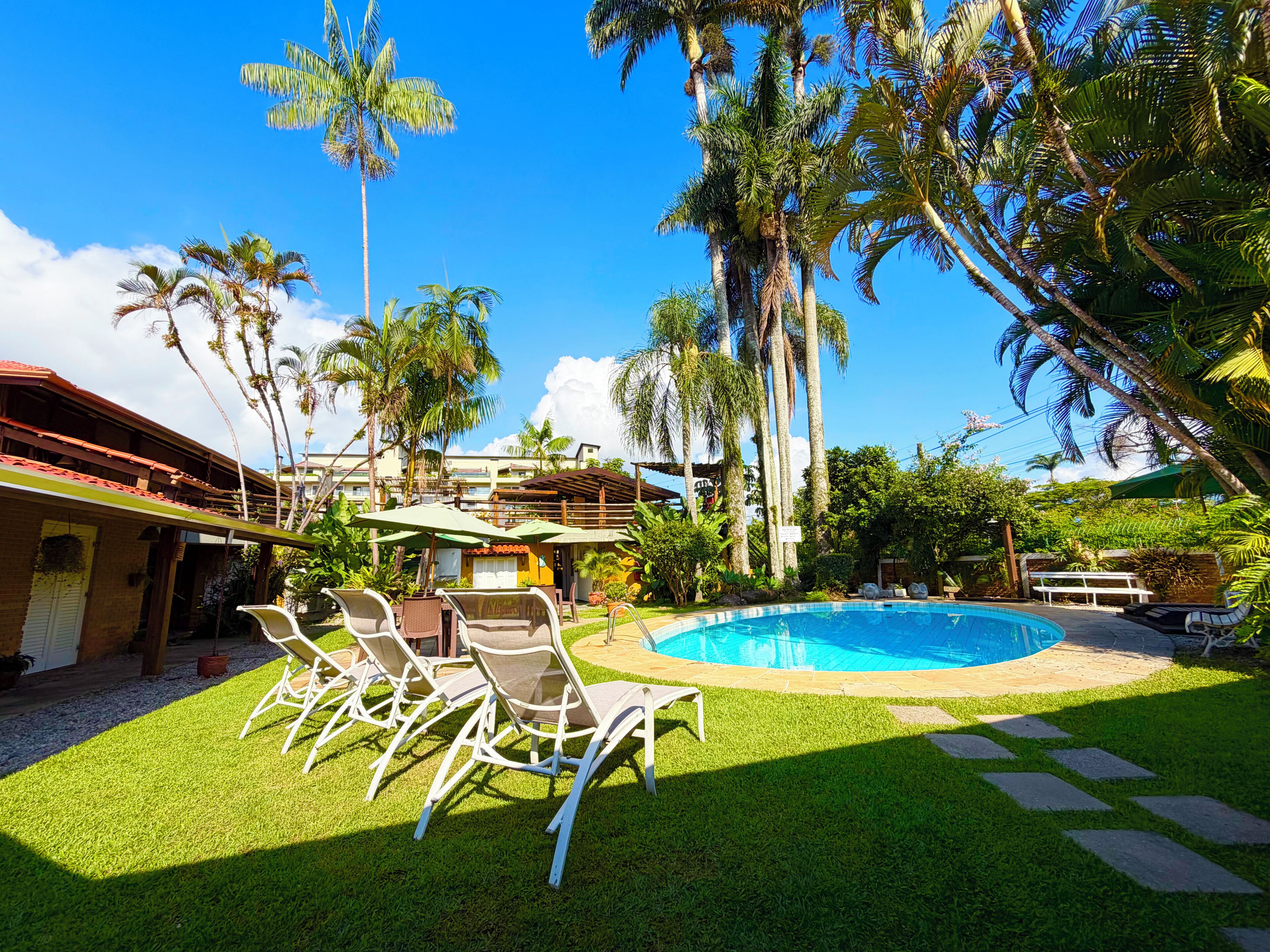 A pool area with lounge chairs, a table, and a sign.