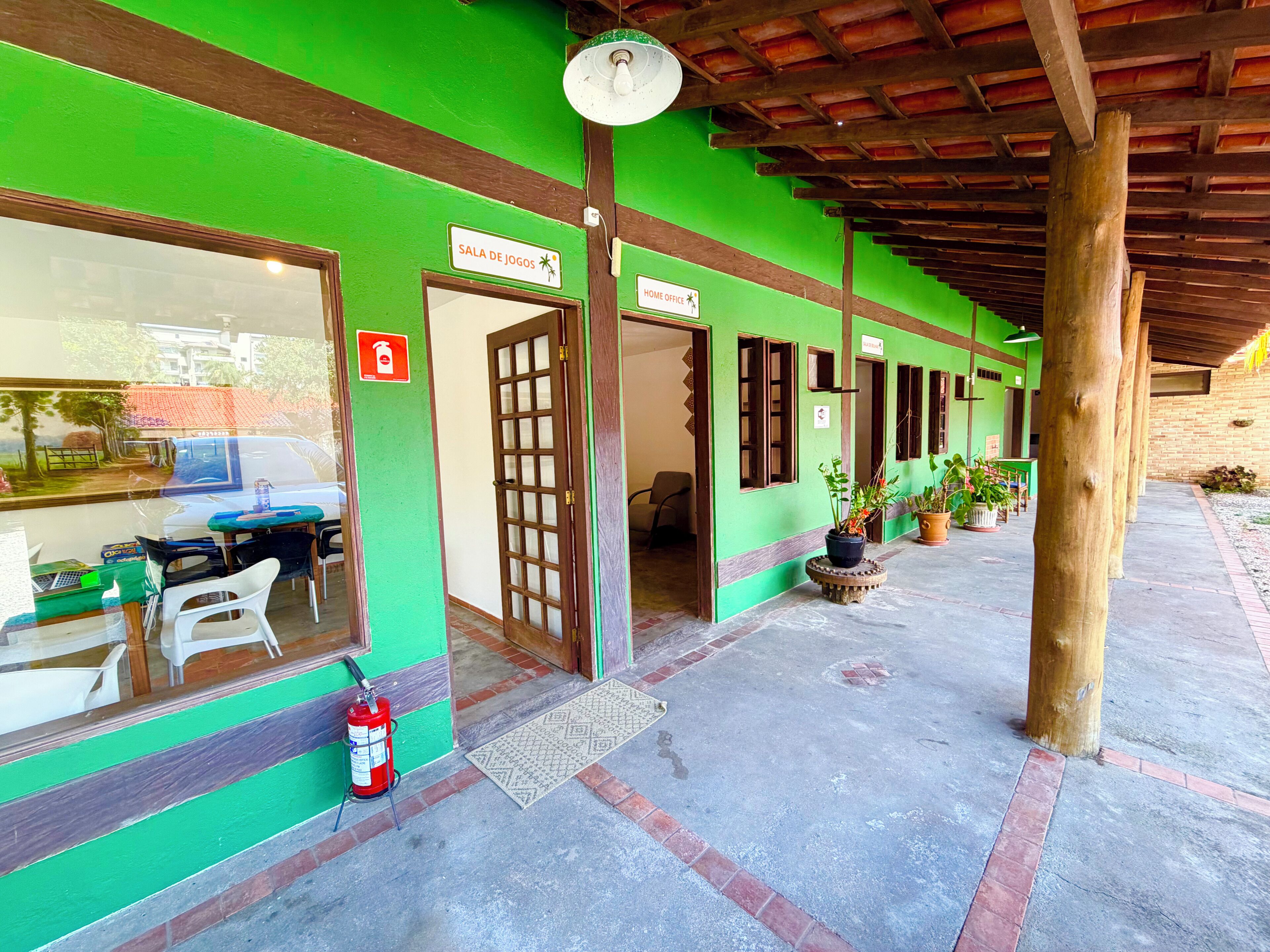 A building with a green exterior, a fire extinguisher, and a sign indicating a home office.