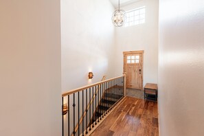 A wooden staircase with a black railing leading to a door with a window above it. - Min to Ski & Lake, 3BR Sleeps 9 + Hot Tub in Black Rock Ridge. (Kamas)