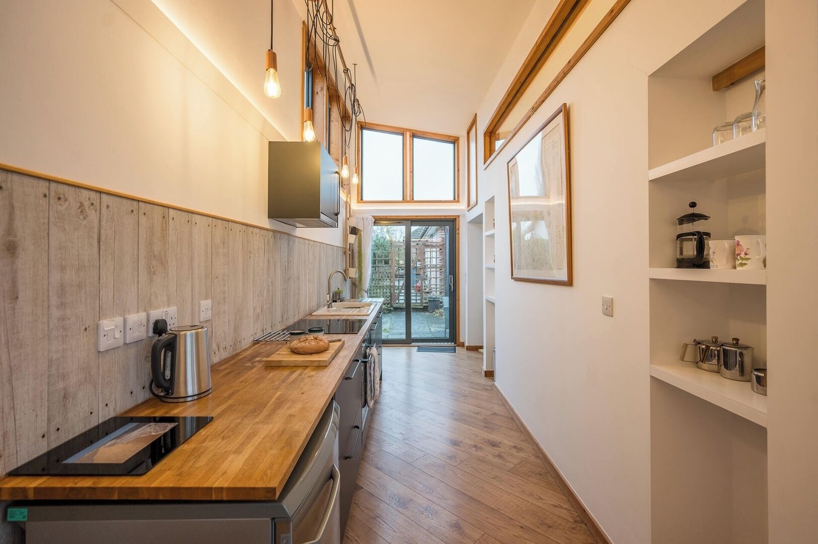 Una cocina moderna con encimera de madera, electrodomésticos integrados y vistas al exterior.