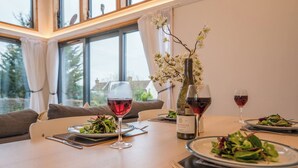 Ett matbord med tallrikar fyllda med sallad, vinglas och en vinflaska.