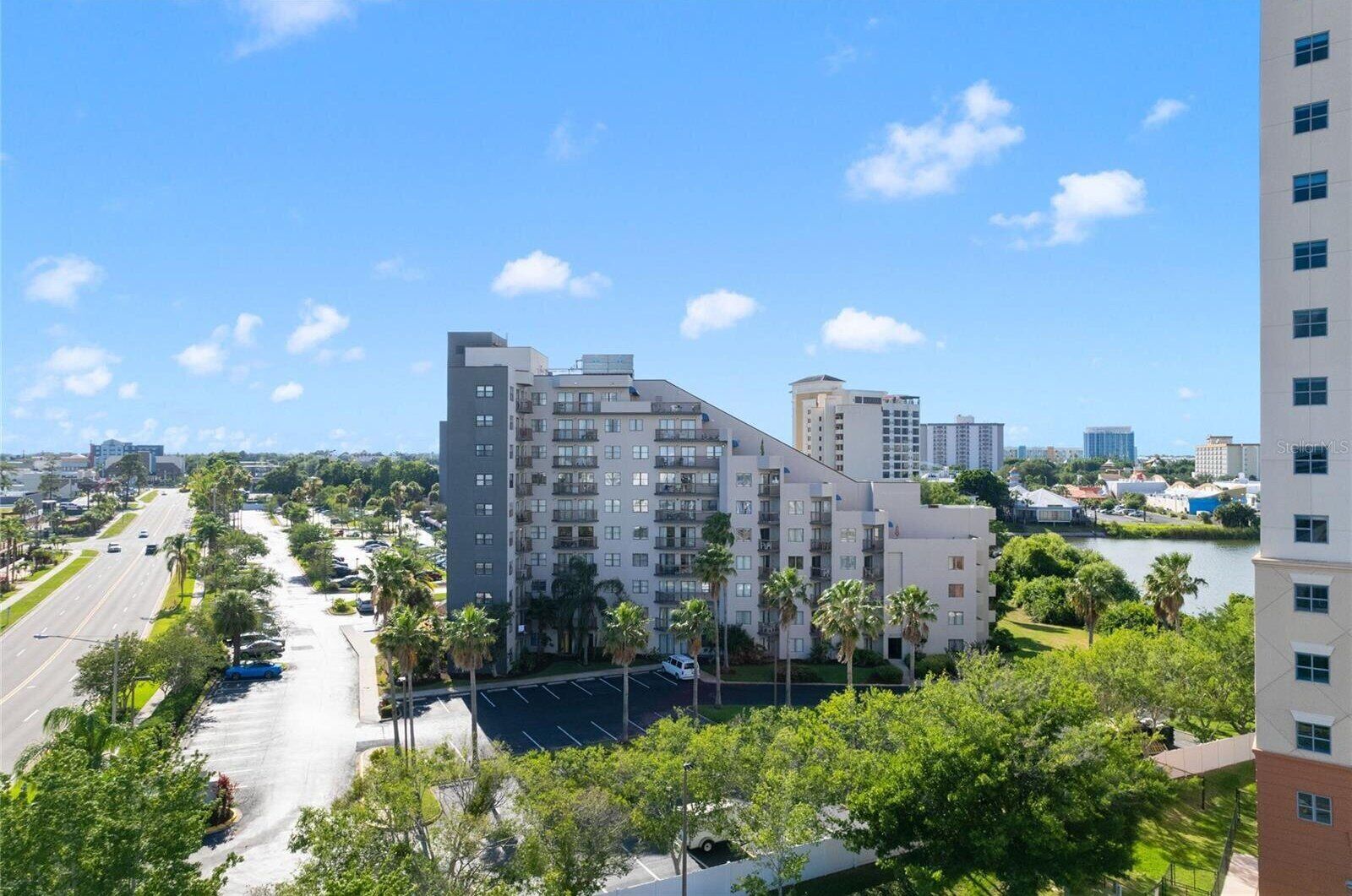 A multi-story building with a parking lot and a road in the foreground.