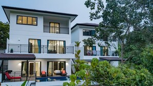 A modern multi-story residential building with balconies, a swimming pool, and a well-maintained garden. - Valley View private pool Villa Phuket (Chalong)