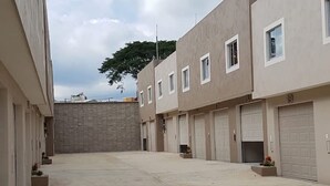 A row of modern buildings with uniform architecture, featuring multiple garage doors and small windows. - Motel Passion (Córdoba)