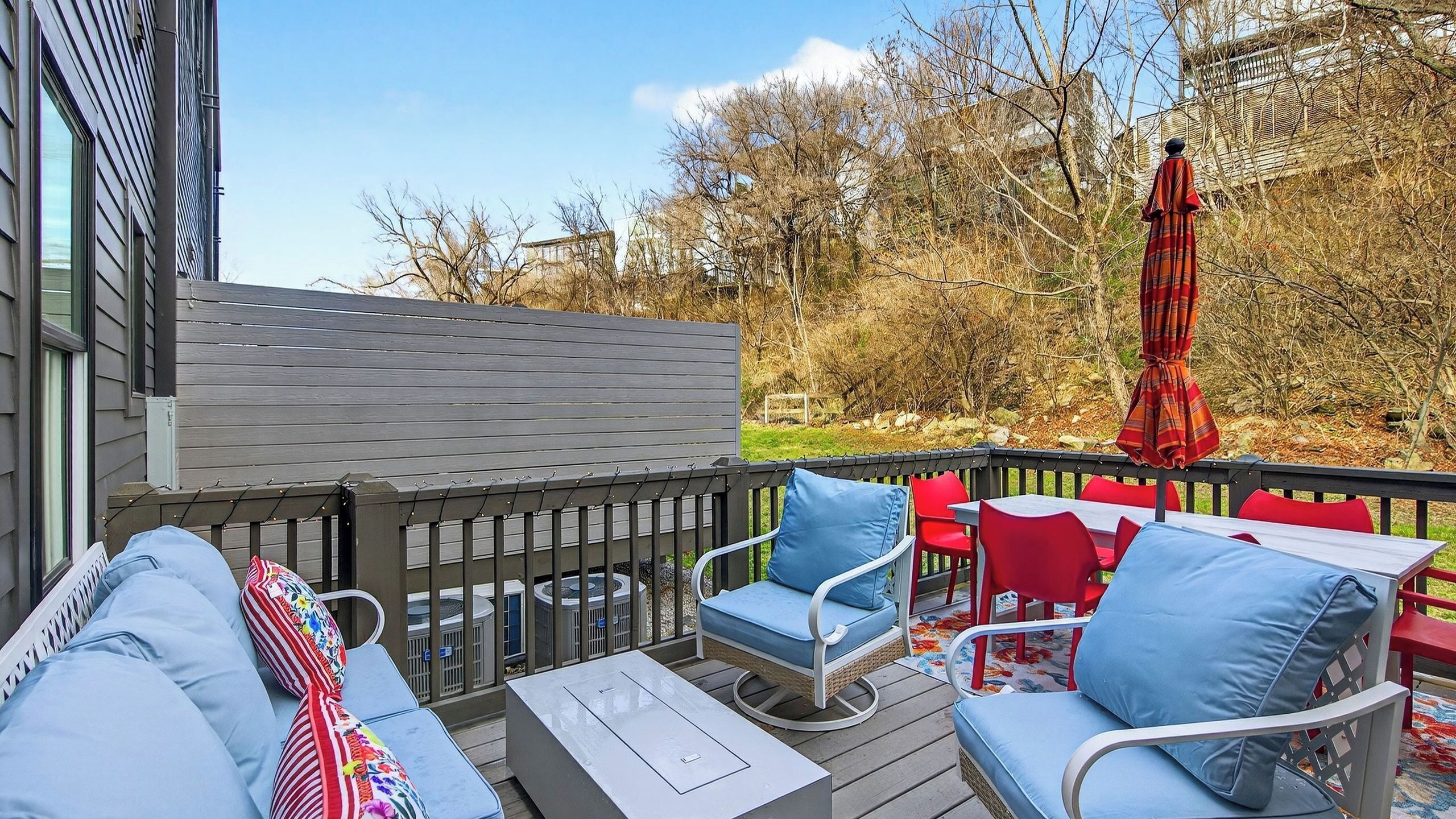 A deck with outdoor furniture, including a sofa, chairs, and a table.