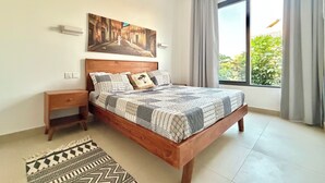Ein Schlafzimmer mit einem hölzernen Bett, einem Nachttisch, einem gemusterten Teppich, einem großen Fenster mit Vorhängen und einem Bild an der Wand.