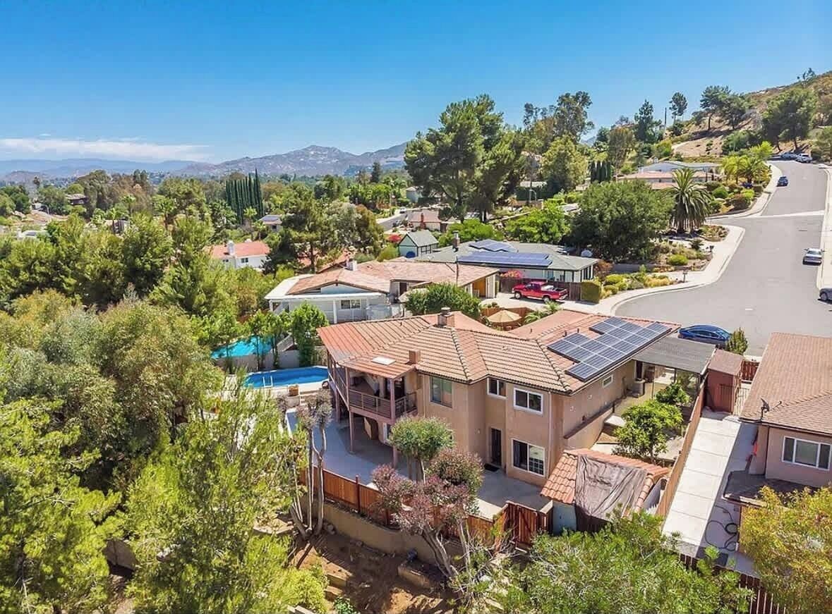 A residential area with houses, a swimming pool, and solar panels.