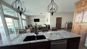 A modern kitchen with granite countertops, a built-in dishwasher, wooden cabinets, and pendant lighting. - Spacious 2 bedroom condo on Lake Kampeska (Watertown)